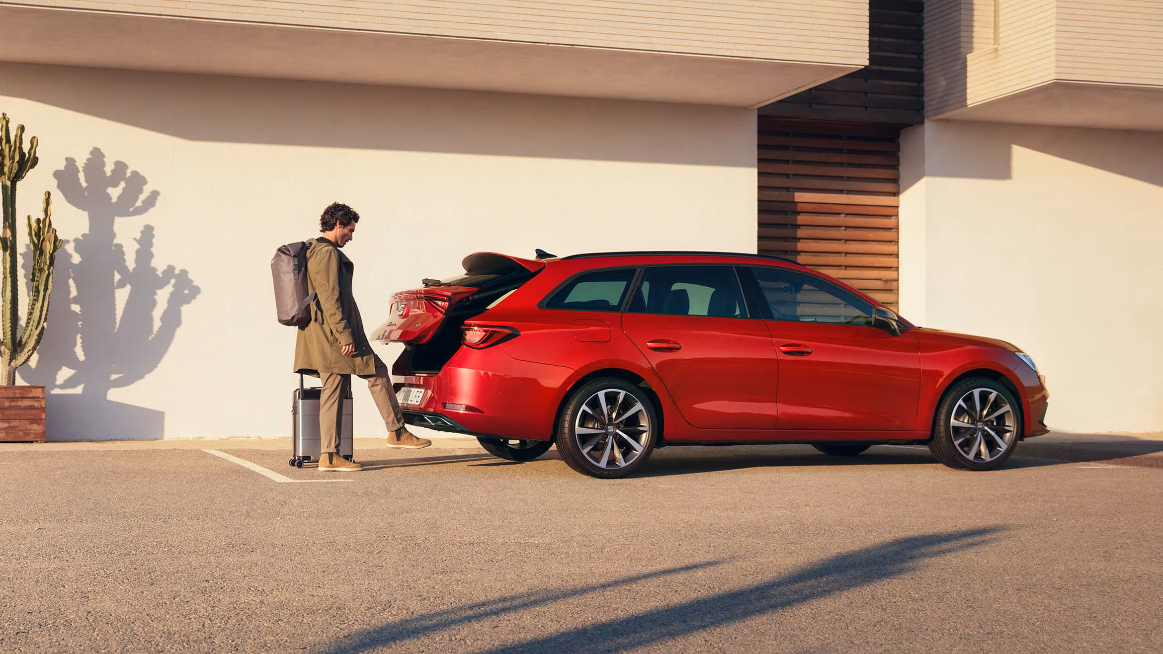 Para siedząca na dachu samochodu rodzinnego SEAT Alhambra, w dzikim krajobrazie