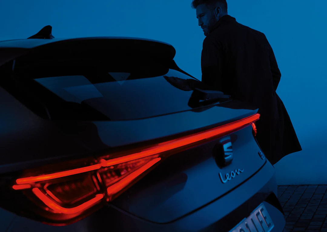 Para siedząca na dachu samochodu rodzinnego SEAT Alhambra, w dzikim krajobrazie